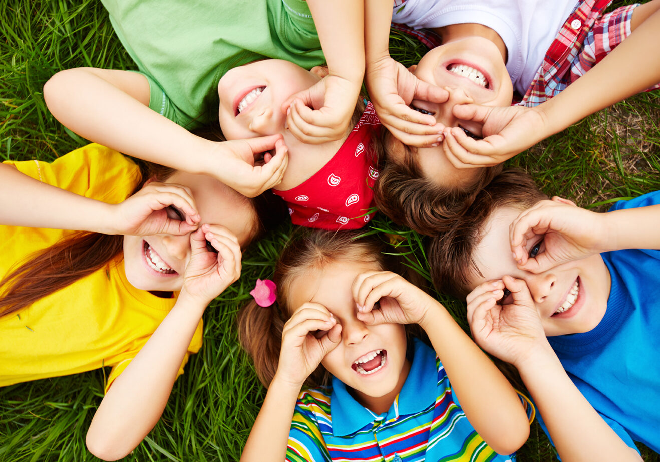 Group of cute children lying on grass